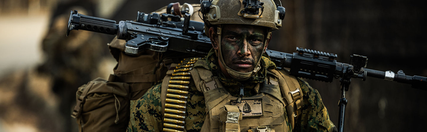 Marine machine gunner carries M240 with ammunition belt during force-on-force training exercise in South Korea.